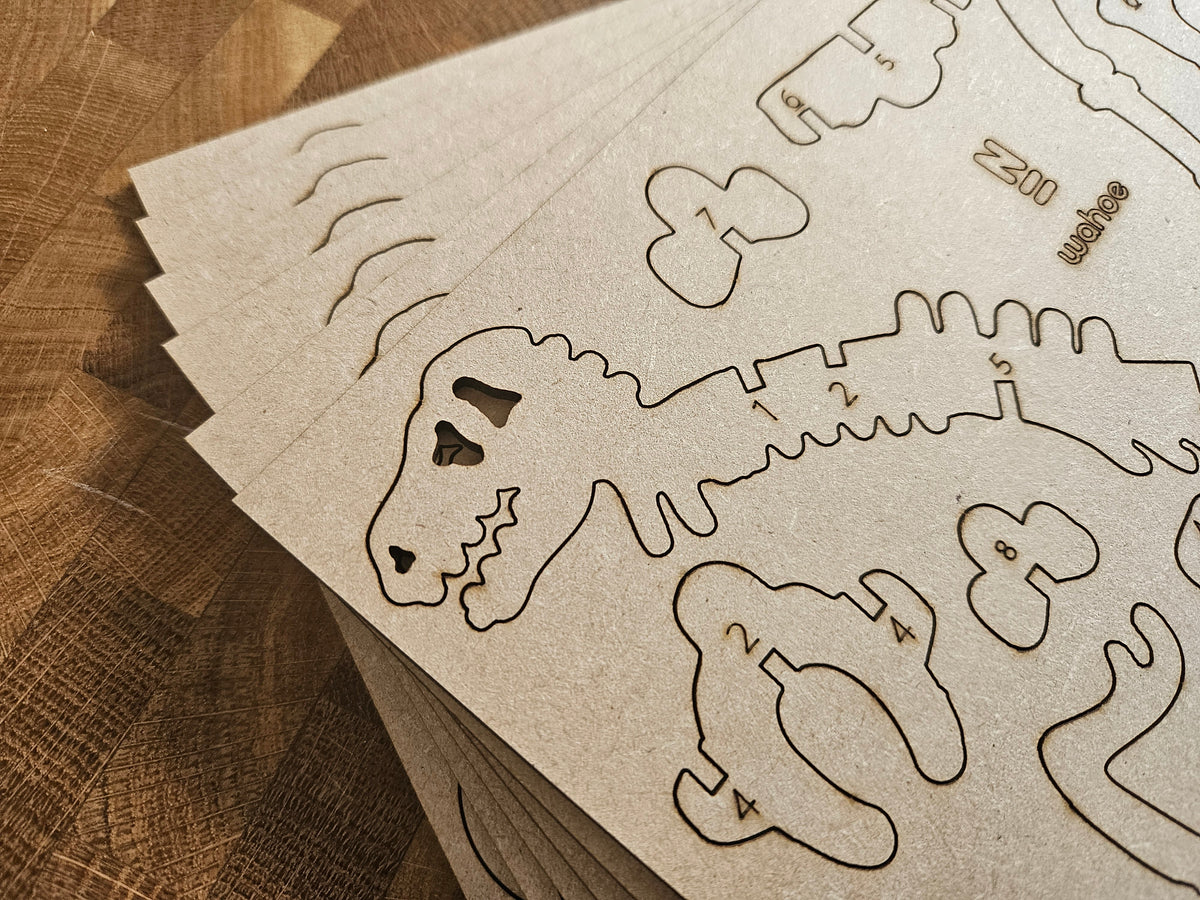 Genummerde bouwonderdelen met de contour van een dinosaurusskelet op gestapelde platen