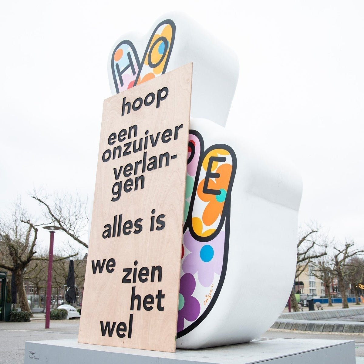 Buiteninstallatie met kleurrijke vormen en een tekstpaneel op een sokkel
