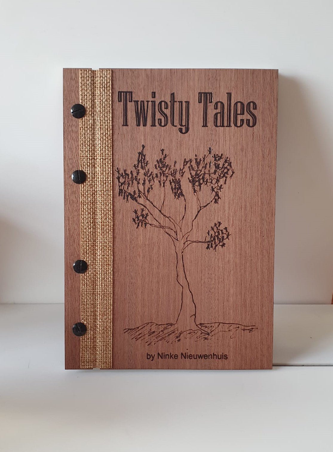 Bruine boekkaft met de titel Twisty Tales en een tekening van een boom