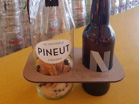 Twee flessen in een platte houder met het opschrift Pineut