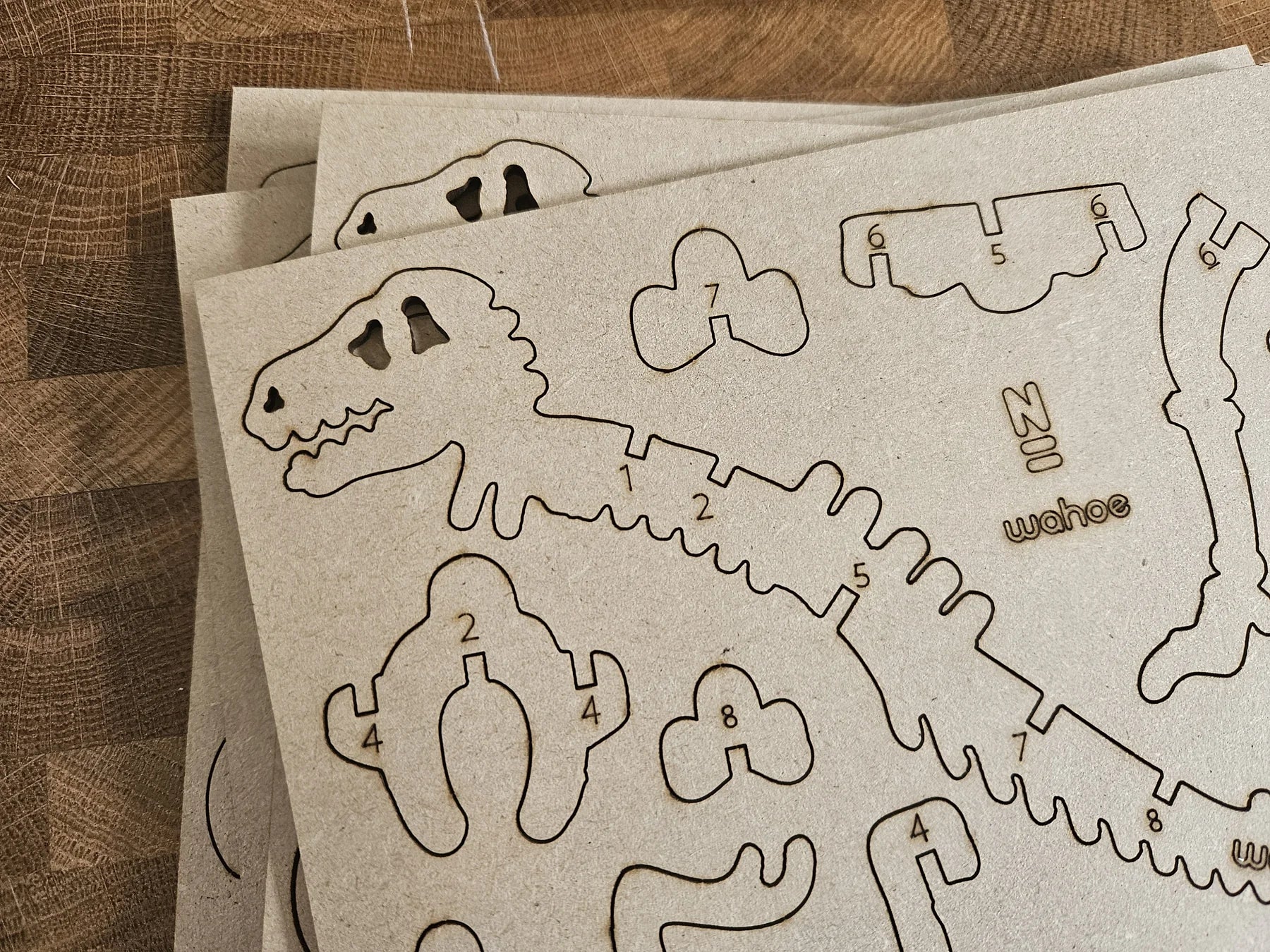 Flat-pack dinosaur model kit with numbered laser-cut parts