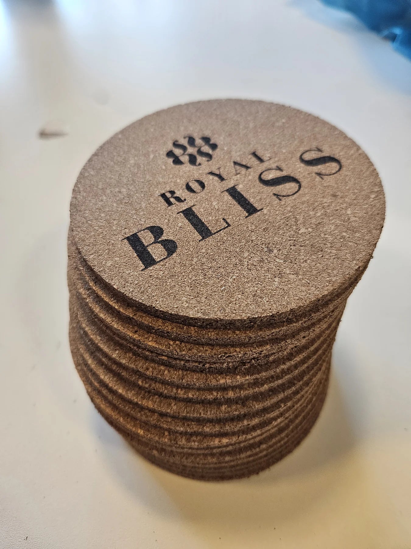 Stack of cork coasters with the same logo engraved